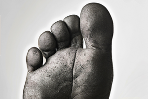 image d'un pied dont nous voyons les empreintes digitales mises en exergue par du carbone pour illustrer le titre : "Que fait l'ESS pour la neutralité carbone ? "