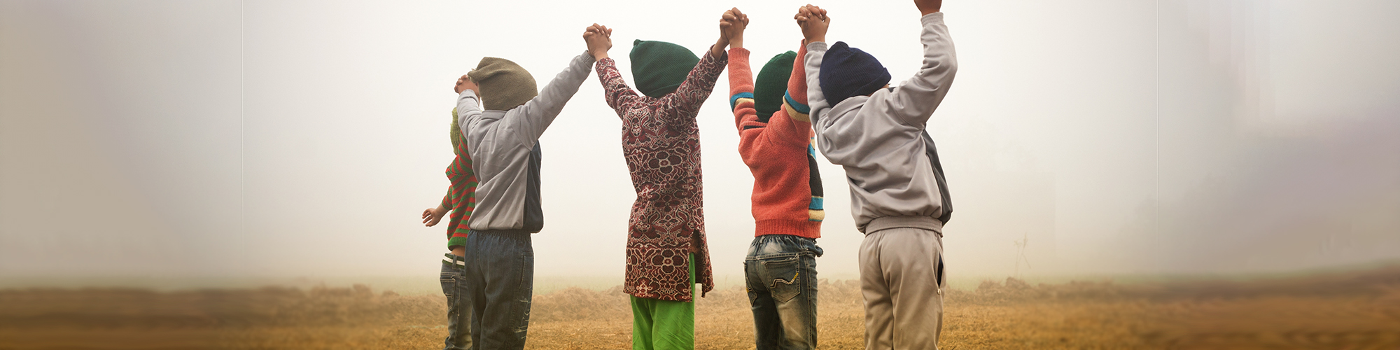 4 enfants se tiennent par la main en regardant l'horizon