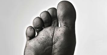 image d'un pied dont nous voyons les empreintes digitales mises en exergue par du carbone pour illustrer le titre : "Que fait l'ESS pour la neutralité carbone ? "
